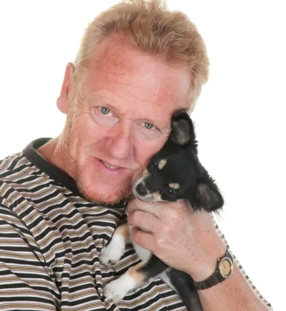 man hugging chihuahua