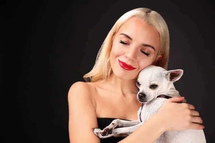 blond woman hugging chihuahua