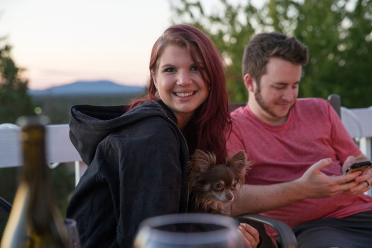 couple with chihuahua sitting outside