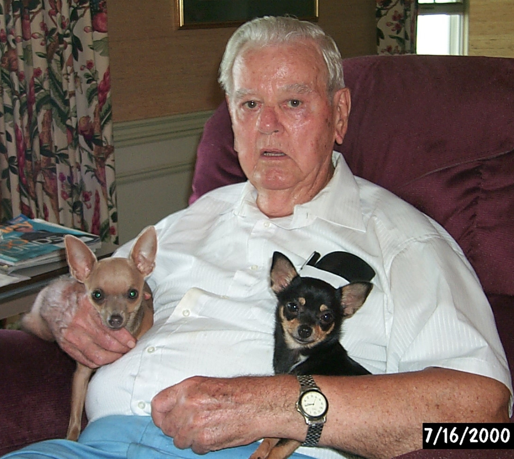 elderly man holding 2 chihuahuas